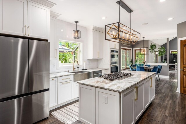 kitchen with appliances with stainless steel finishes, a chandelier, a sink, dark wood-style flooring, and recessed lighting