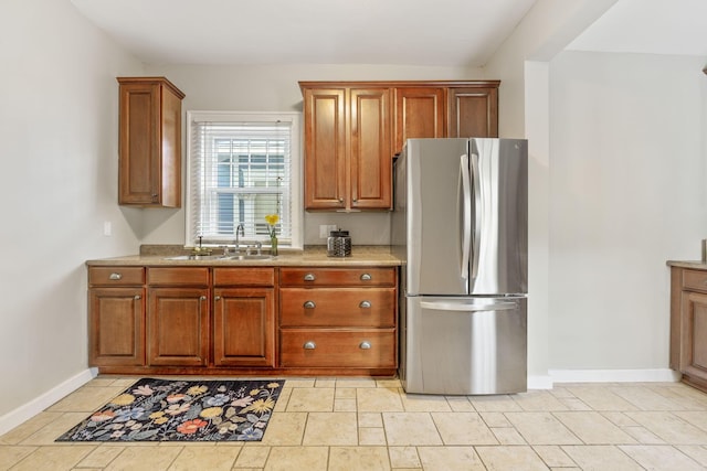 300 N Franklin St, Delaware, OH 43015 - kitchen featuring baseboards, a sink, freestanding refrigerator, brown cabinetry, and light stone counters