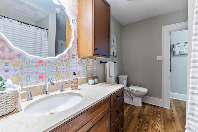 300 N Franklin St, Delaware, OH 43015 - bathroom featuring toilet, vanity, wood finished floors, and baseboards