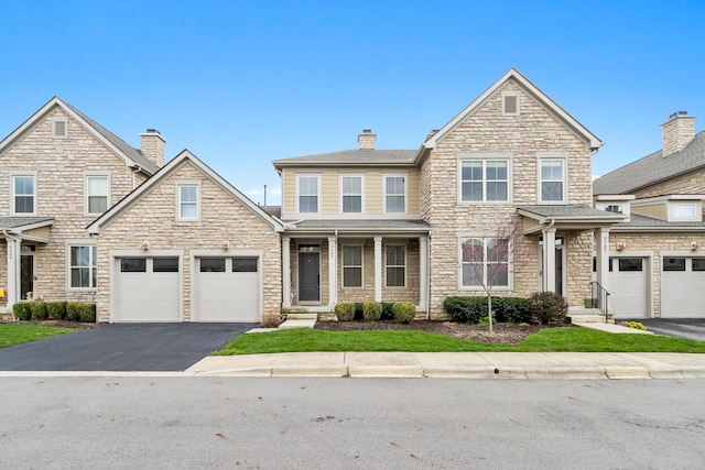 3697 Echo Pl, Powell, OH 43065 - craftsman-style house with driveway, stone siding, a chimney, covered porch, and a garage