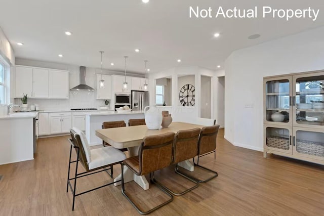 dining area with recessed lighting, plenty of natural light, and wood finished floors