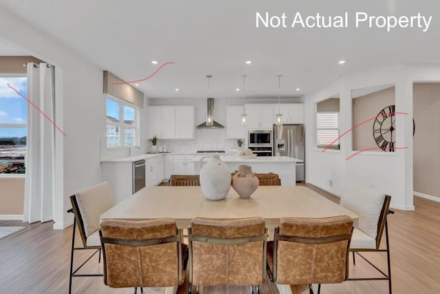 dining room with baseboards, light wood-style floors, and recessed lighting