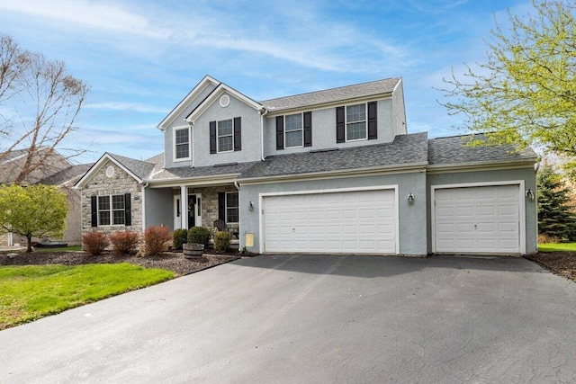 traditional-style house with a garage, driveway, stone siding, and stucco siding