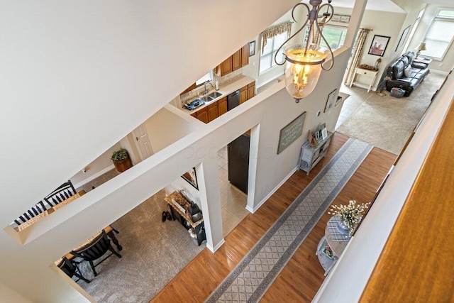 stairs featuring baseboards, a high ceiling, and wood finished floors