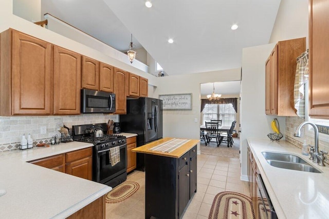 kitchen with a sink, a chandelier, black appliances, backsplash, and light tile patterned flooring