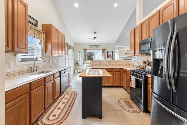 kitchen with light countertops, a peninsula, a sink, and stainless steel appliances