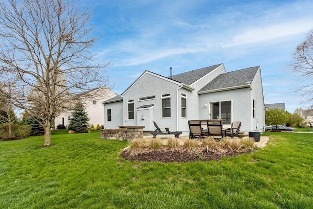 rear view of house with a patio, a yard, and stucco siding