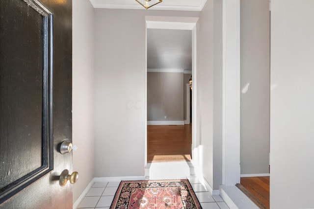 hall featuring ornamental molding, baseboards, and tile patterned floors