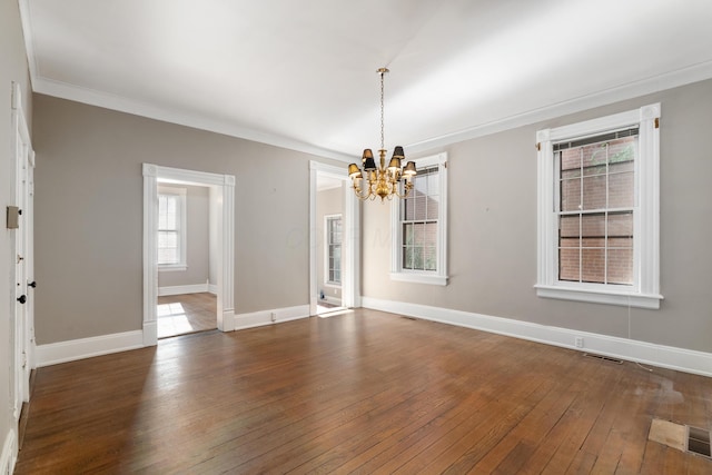 unfurnished dining area with a chandelier, hardwood / wood-style floors, baseboards, and ornamental molding