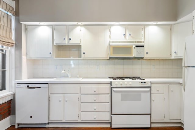 kitchen featuring white appliances, a sink, light countertops, and backsplash
