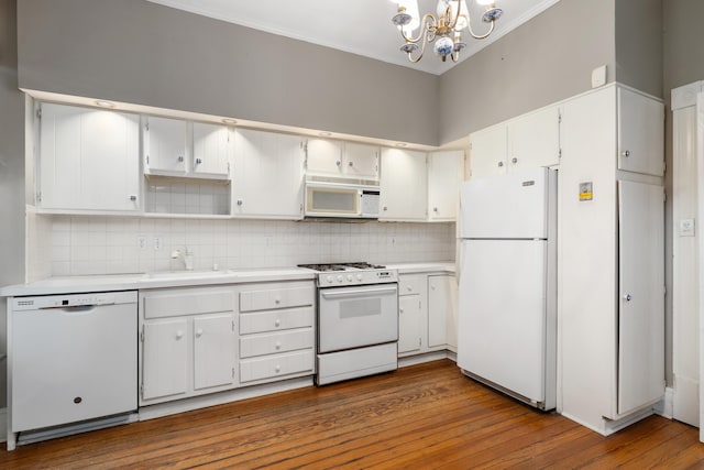 kitchen with white appliances, a sink, a chandelier, backsplash, and light countertops