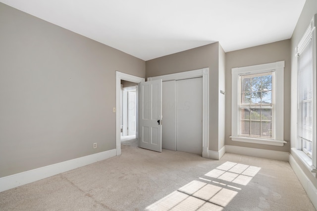 unfurnished bedroom with carpet floors, baseboards, and a closet