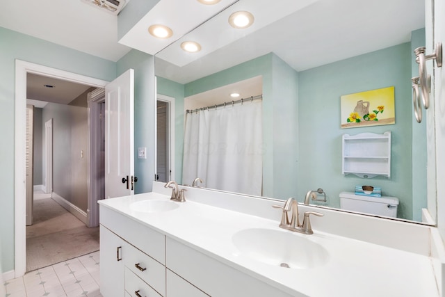 full bathroom with double vanity, recessed lighting, toilet, and baseboards
