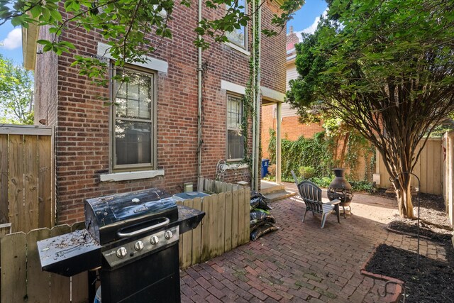 view of patio / terrace with a grill and fence