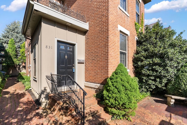 doorway to property featuring brick siding