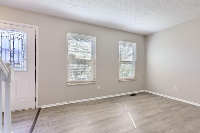 3225 Bellerive Dr, Pickerington, OH 43147 - foyer entrance with a textured ceiling, wood finished floors, baseboards, and plenty of natural light