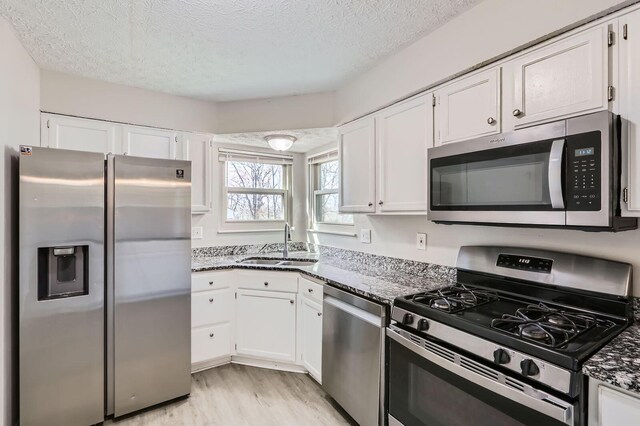 3225 Bellerive Dr, Pickerington, OH 43147 - kitchen featuring a textured ceiling, a sink, white cabinetry, and stainless steel appliances