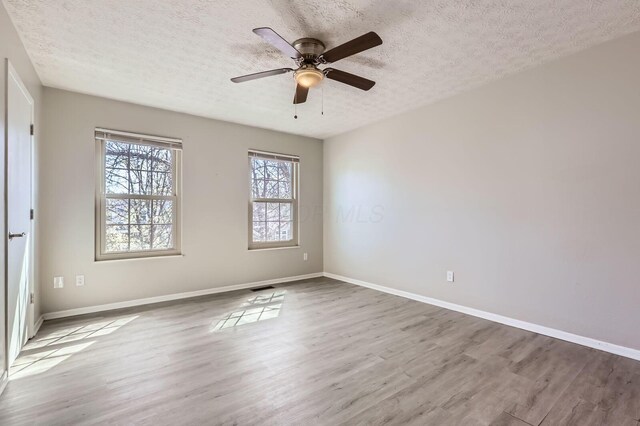3225 Bellerive Dr, Pickerington, OH 43147 - empty room featuring a textured ceiling, wood finished floors, and baseboards