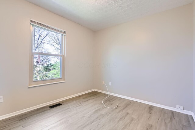 3225 Bellerive Dr, Pickerington, OH 43147 - spare room featuring a textured ceiling, wood finished floors, baseboards, and visible vents