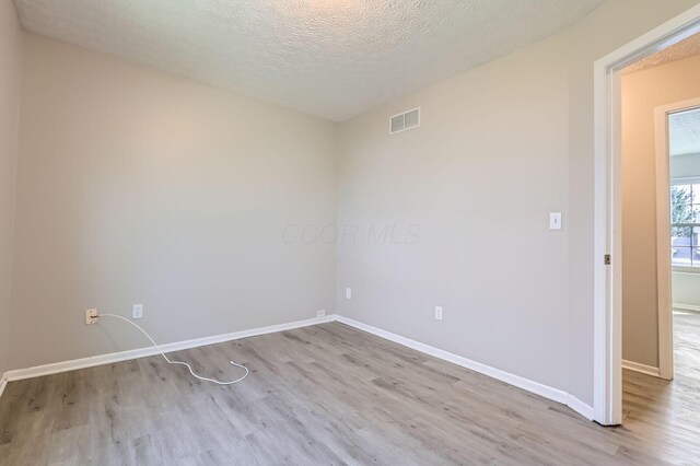 3225 Bellerive Dr, Pickerington, OH 43147 - unfurnished room featuring visible vents, baseboards, wood finished floors, and a textured ceiling