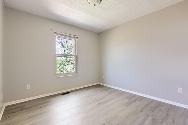 3225 Bellerive Dr, Pickerington, OH 43147 - spare room featuring visible vents, a textured ceiling, baseboards, and wood finished floors