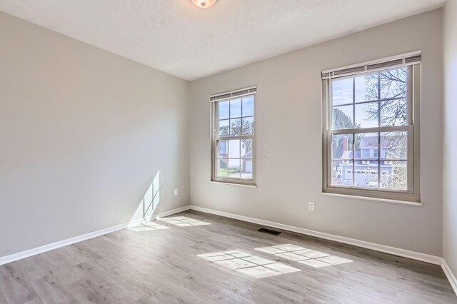 3225 Bellerive Dr, Pickerington, OH 43147 - empty room featuring visible vents, baseboards, wood finished floors, and a textured ceiling