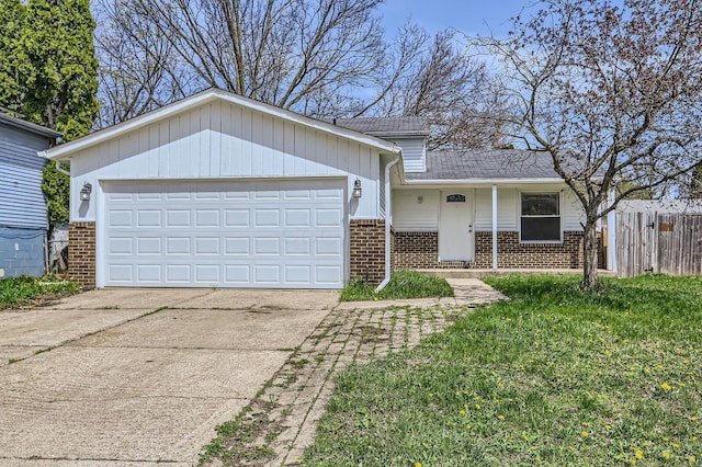 view of front of home with fence, an attached garage, driveway, and brick siding
