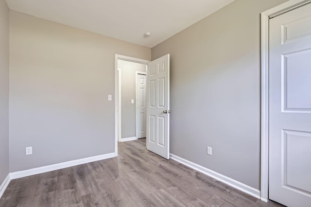 unfurnished room with baseboards and wood finished floors