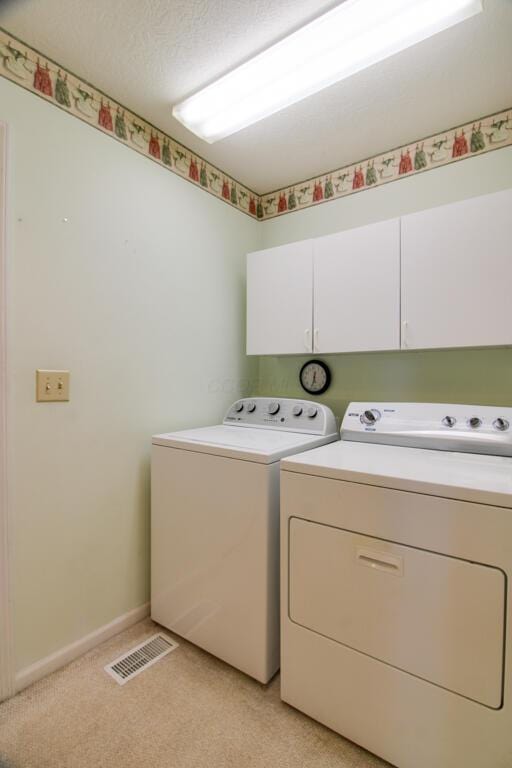 2266 Feather Ln, Marion, OH 43302 - washroom featuring baseboards, a textured ceiling, visible vents, cabinet space, and washer and dryer
