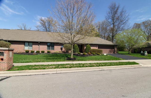 2266 Feather Ln, Marion, OH 43302 - ranch-style house featuring an attached garage, driveway, a front yard, and brick siding