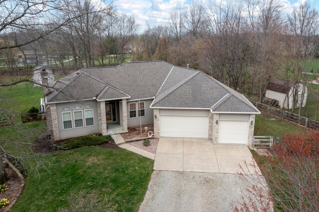 view of front facade with a front yard, a shingled roof, a garage, fence, and driveway