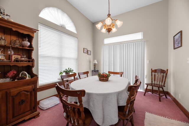 dining space featuring carpet flooring, baseboards, and an inviting chandelier