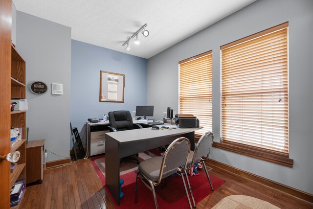 office with wood-type flooring, baseboards, and track lighting