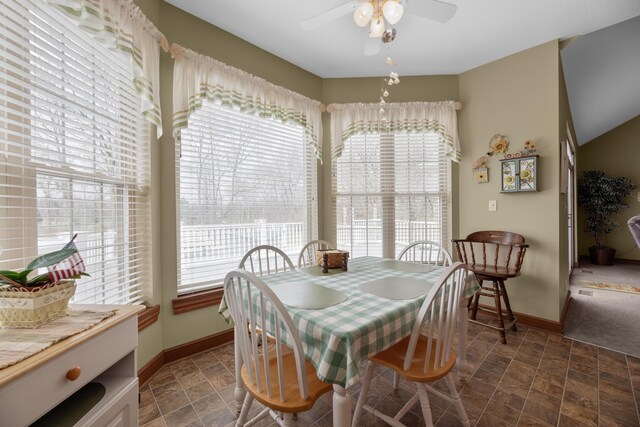 dining room featuring plenty of natural light, stone finish floor, baseboards, and ceiling fan