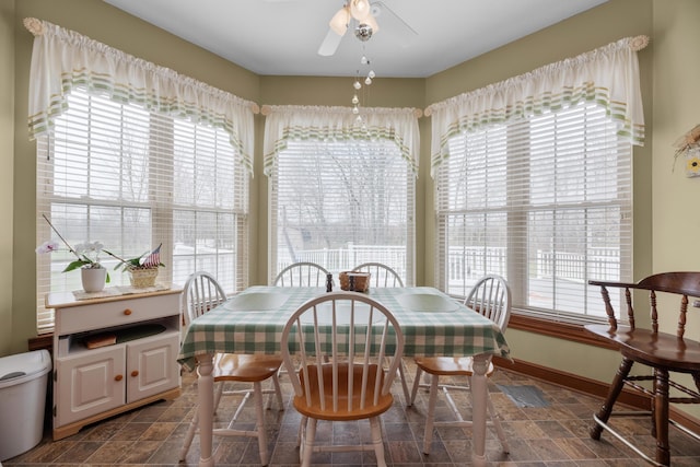 dining space with a healthy amount of sunlight, baseboards, and a ceiling fan