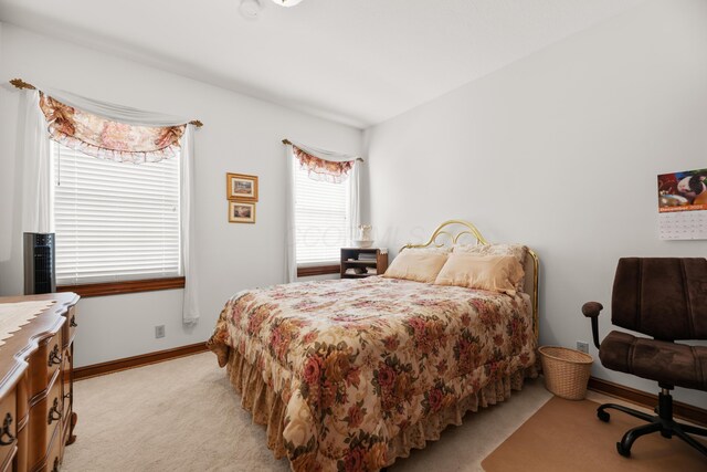 bedroom with light carpet and baseboards