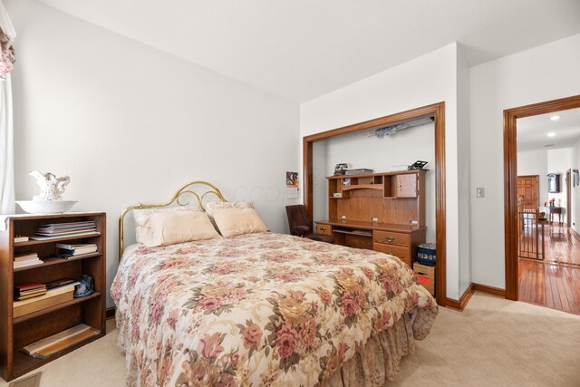 bedroom featuring light carpet and baseboards