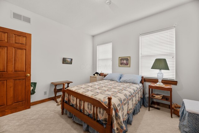 bedroom featuring visible vents, baseboards, and light colored carpet