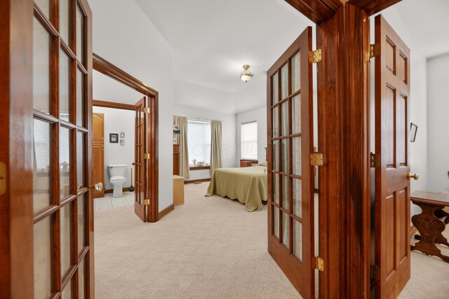 hallway featuring french doors, baseboards, and carpet