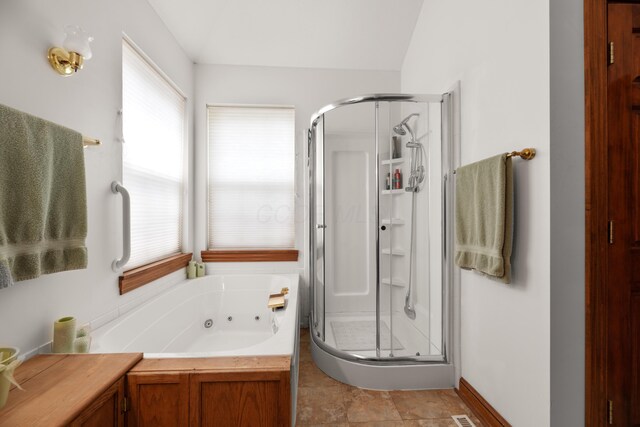bathroom featuring a stall shower and a tub with jets