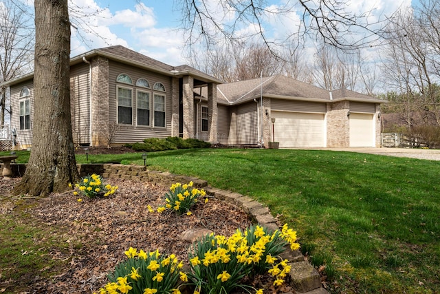 prairie-style home with brick siding, driveway, an attached garage, and a front lawn