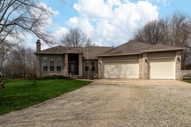 view of front of property with a front yard, brick siding, driveway, and an attached garage
