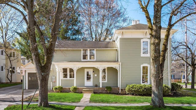134 N Pearl St, Granville, OH 43023 - italianate home featuring a porch, a front yard, a garage, driveway, and a chimney