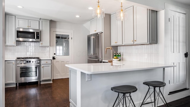 134 N Pearl St, Granville, OH 43023 - kitchen with dark wood-style floors, gray cabinetry, high quality appliances, and decorative backsplash