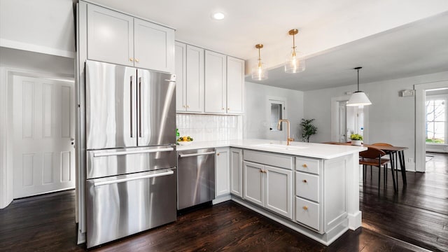 134 N Pearl St, Granville, OH 43023 - kitchen with a sink, a peninsula, stainless steel appliances, and light countertops