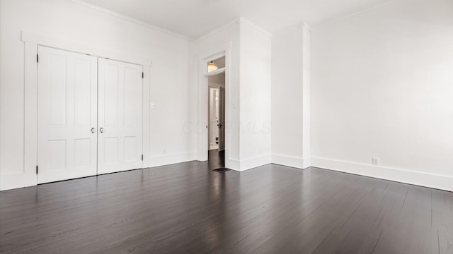 134 N Pearl St, Granville, OH 43023 - unfurnished bedroom with crown molding, a closet, baseboards, and dark wood-type flooring
