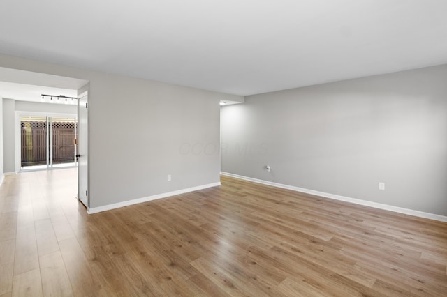unfurnished room featuring light wood finished floors and baseboards