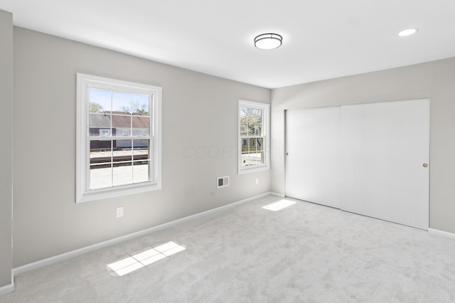 unfurnished bedroom with a closet, carpet flooring, baseboards, and visible vents