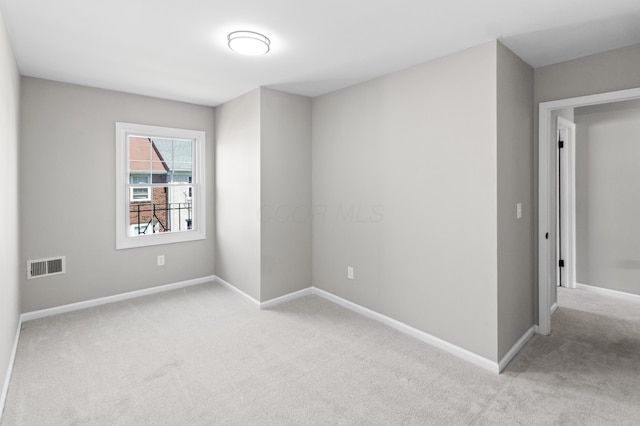 unfurnished room featuring light colored carpet, baseboards, and visible vents