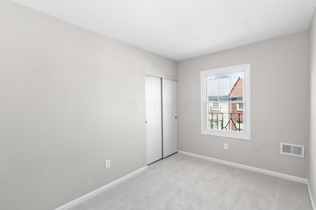 unfurnished bedroom featuring visible vents, baseboards, and light carpet